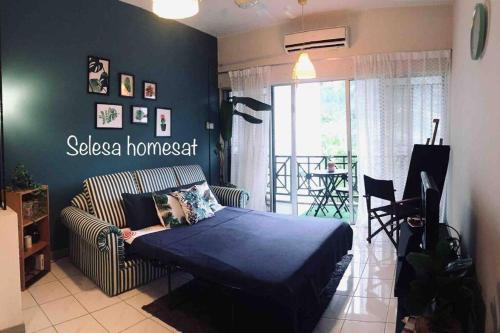 ein Schlafzimmer mit einem Bett und einer Couch in einem Zimmer in der Unterkunft THE GREEN @SELESA HILLHOMES BUKIT TINGGI BENTONG in Bentong