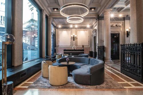 a lobby with a couch and a table and chairs at Radisson Collection Hotel, Palazzo Touring Club Milan in Milan