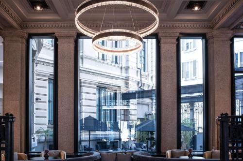 a lobby with a chandelier and large windows at Radisson Collection Hotel, Palazzo Touring Club Milan in Milan