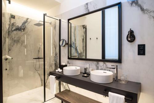 a bathroom with two sinks and a shower at Radisson Collection Hotel, Palazzo Touring Club Milan in Milan