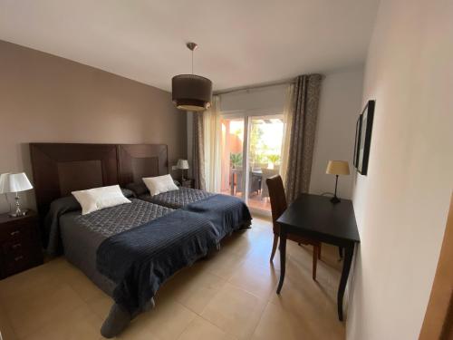 トレ・パチェコにあるApto. Mar Menor Golf Resortのベッドルーム1室(ベッド1台、デスク、窓付)