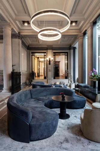 a large lobby with blue couches and a chandelier at Radisson Collection Hotel, Palazzo Touring Club Milan in Milan