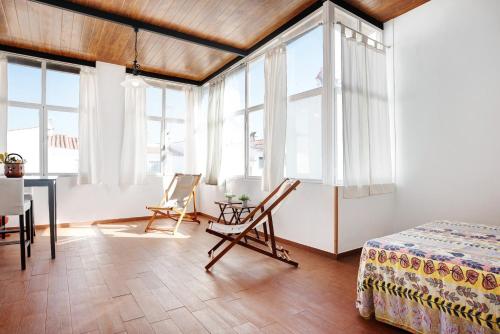 um quarto com janelas e uma mesa e cadeiras em Las torres em Chiclana de la Frontera