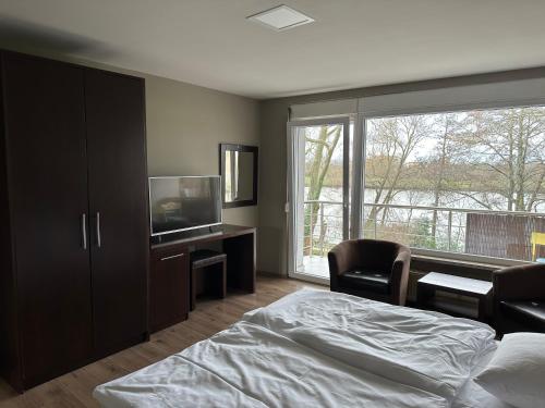 a bedroom with a bed and a tv and a window at main Appartments in Kelsterbach