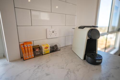 a kitchen counter with a hair dryer next to a refrigerator at Moonta Bay Holiday Park in Port Moonta