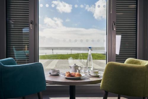 a table with a plate of food next to a window at Caban, Pendine Sands in Pendine