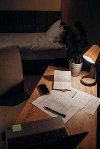 a desk with a laptop computer and papers on it at Redwood Hostel by EASY RENT Apartments in Lublin