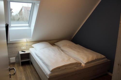 a bed in a small room with a window at LA2g Galerie - Ferienreihenhaus LA2 in Schottwarden
