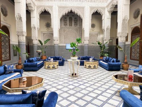 eine große Lobby mit blauen Sofas und Tischen in der Unterkunft Le Riad Palais d'hotes Suites & Spa Fes in Fès