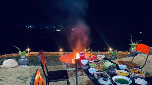 Une table avec de la nourriture à côté d'un feu dans l'établissement Du Gia Panorama, à Làng Cac