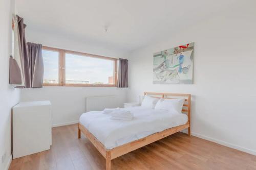 een witte slaapkamer met een bed en een raam bij Unique Spacious Central 3 Bedroom with Rooftop Terrace in Londen