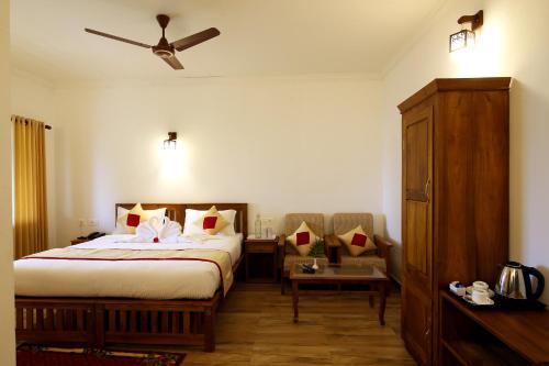 a bedroom with a bed and a ceiling fan at Dew Drops Farm Resorts in Munnar
