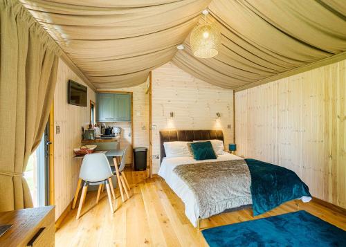 a bedroom with a bed and a desk in a room at Riverside Cabins in Shrewsbury