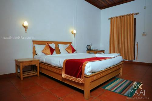 a bedroom with a large bed with a red blanket at Dew Drops Farm Resorts in Munnar