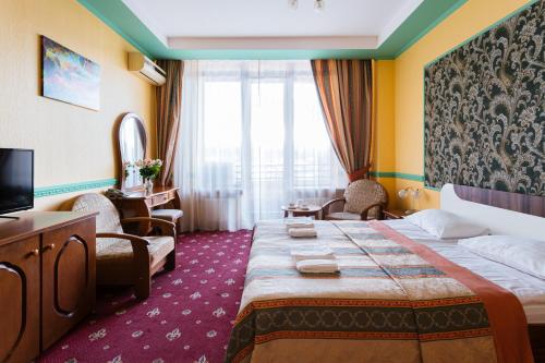 um quarto de hotel com uma cama grande e uma televisão em Tiso Apart Hotel em Kiev