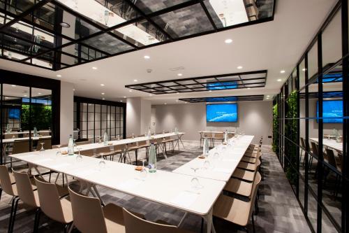 a large conference room with long tables and chairs at Catalonia Conde de Floridablanca in Murcia