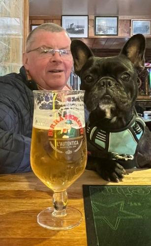 a man sitting at a table with a glass of beer at Seafield Arms Hotel in Whitehills