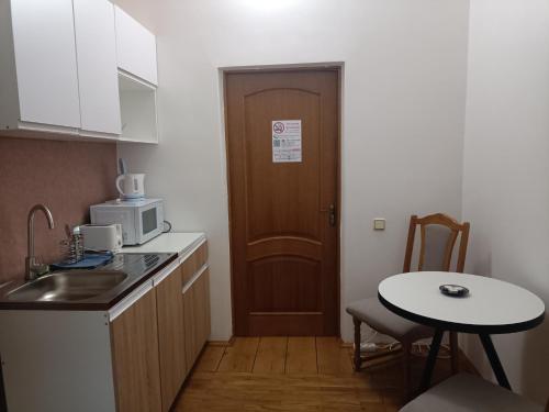 eine kleine Küche mit einem Tisch und einer Tür in der Unterkunft Pysanka Hotel in Kolomyja