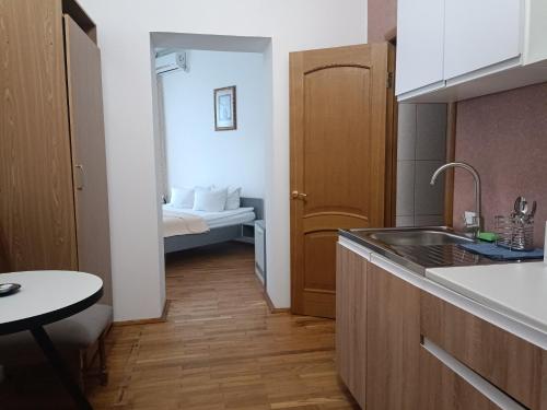 eine Küche mit einem Waschbecken und ein Zimmer mit einem Bett in der Unterkunft Pysanka Hotel in Kolomyja