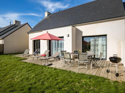 un patio avec une table, des chaises et un barbecue dans l'établissement Holiday Home La Goulvinoise by Interhome, à Goulven