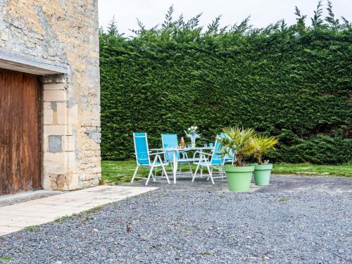 a patio with chairs and a table with plants at Holiday Home Le Clos Renard by Interhome in Commes