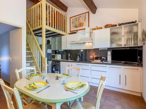 ein Esszimmer mit einem Tisch und Stühlen sowie eine Küche in der Unterkunft Holiday Home Le Clos d'Azur 1 - LMO138 by Interhome in La Motte