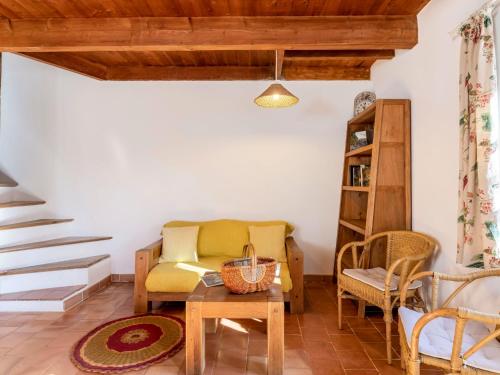 un salon avec une chaise jaune et une table dans l'établissement Holiday Home Le Moulin de Verfeuil by Interhome, à Verfeuil