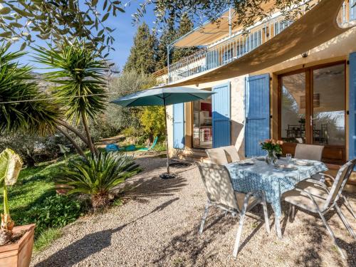 a patio with a table and chairs and an umbrella at Apartment La Petite Toscane - CBX100 by Interhome in Cabris