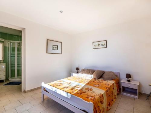a bedroom with a bed with an orange blanket at Apartment La Petite Toscane by Interhome in Cabris