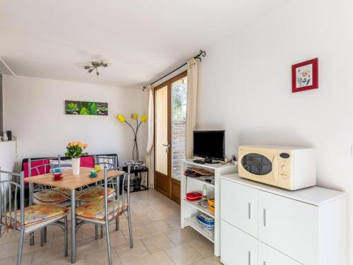 a living room with a table and a microwave at Apartment La Petite Toscane by Interhome in Cabris