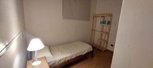 Habitación pequeña con cama pequeña y lámpara en Habitación Individual en Casa Compartida tipo PH - Sólo Mujeres- Women Only en Buenos Aires