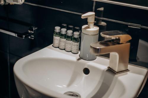 a white sink in a bathroom with bottles on it at Redwood Hostel in Lublin
