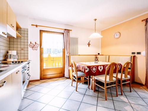 eine Küche und ein Esszimmer mit einem Tisch und Stühlen in der Unterkunft Apartment Carmen-4 by Interhome in Soraga