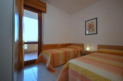 ビビオーネにあるVillaggio Seleneのベッド2台と窓が備わるホテルルームです。