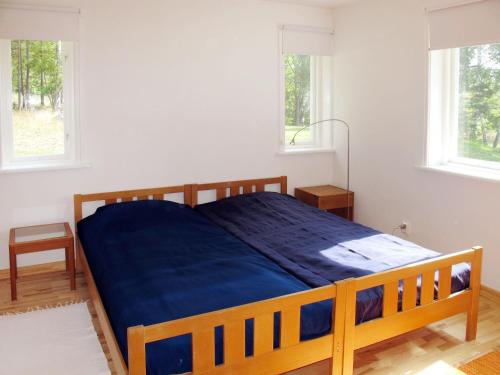 1 dormitorio con cama de madera y manta azul en Chalet Lindby Karneolen - STH151 by Interhome, en Adelsö