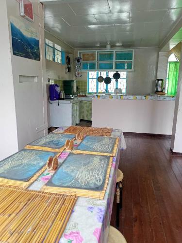 two beds in a room with a kitchen at Banaue Transient House Bed and Breakfast in Banaue