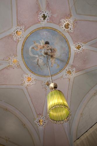 a chandelier hanging from a ceiling with a painting on it at Historical Suites VVM in Lecce