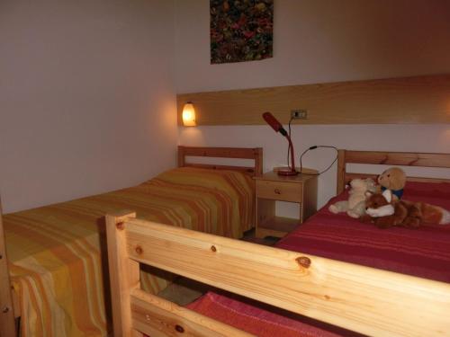 two beds in a bedroom with two teddy bears at Three-Bedroom Villa with garden, parking and ac in Bibione