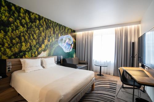 a hotel room with a bed and a desk at Novotel Vilnius Centre in Vilnius