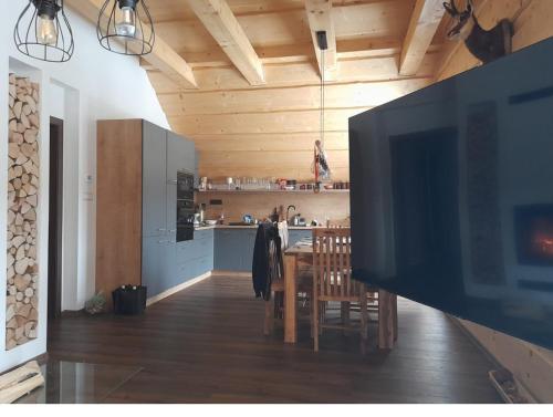 a kitchen and dining room with a large flat screen tv at Apartmánový Dom Terchová in Terchová