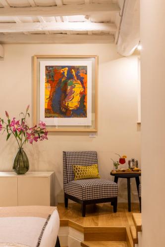 a room with a chair and a table with a painting at Nerva Boutique Hotel in Rome