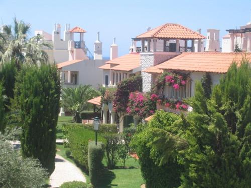 una casa con giardino fiorito e alberi di Old Village a Vilamoura