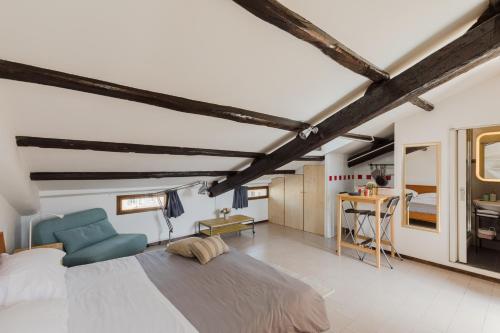 ein Schlafzimmer mit einem großen Bett und einem blauen Stuhl in der Unterkunft La mansarda del Papa - Zen Real Estate in Rom