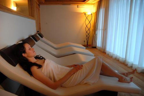 a woman laying in a bath tub in a room at Parc Hotel Miramonti in Fiè