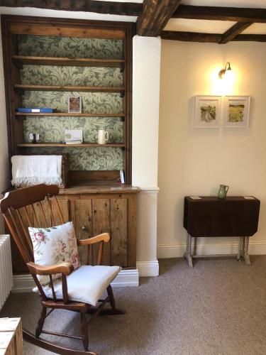 a room with a rocking chair and a table at Rock View Cottage, 2 bedrooms near Alton Towers in Alton