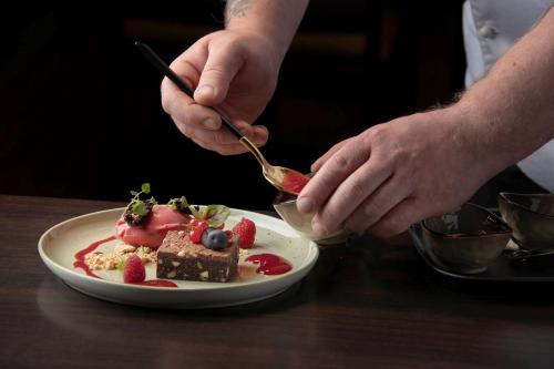 a person is eating a piece of food on a plate at Park Inn by Radisson Oslo Airport Hotel West in Gardermoen