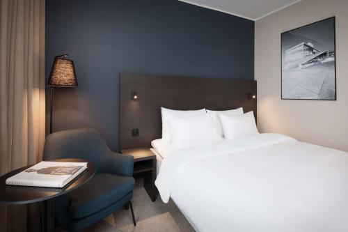 a hotel room with a bed and a desk and a chair at Park Inn by Radisson Oslo Airport Hotel West in Gardermoen