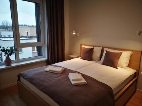 a bedroom with a large bed with two towels on it at Apartamentai centre in Birštonas