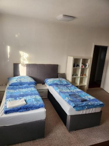 a bedroom with two beds with blue sheets at Homestay u Hanky in Zdiby