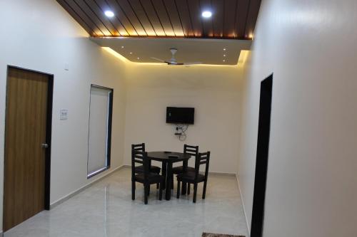 a dining room with a table and chairs and a tv at Flamingo Club and Resort Una 3 Km Away from Diu Check Post in Diu